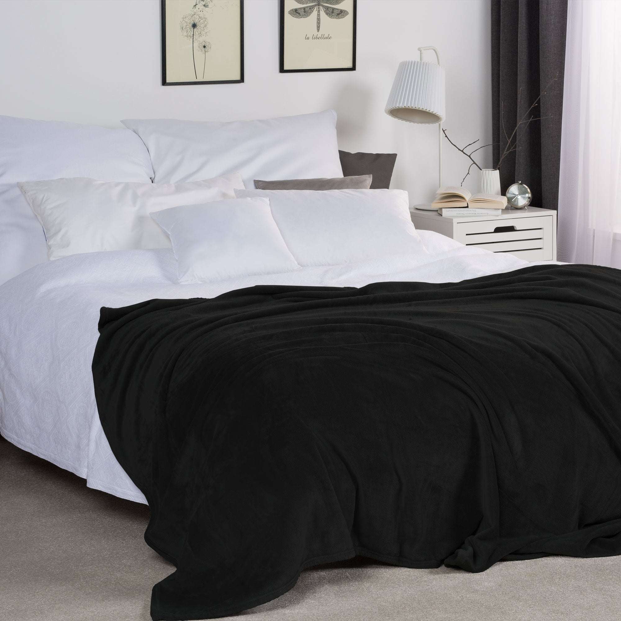 Luxurious black Beautissu XXL Tagesdecke Kuscheldecke Aurelia 220x240cm elegantly draped over a cozy bed in a stylish bedroom.