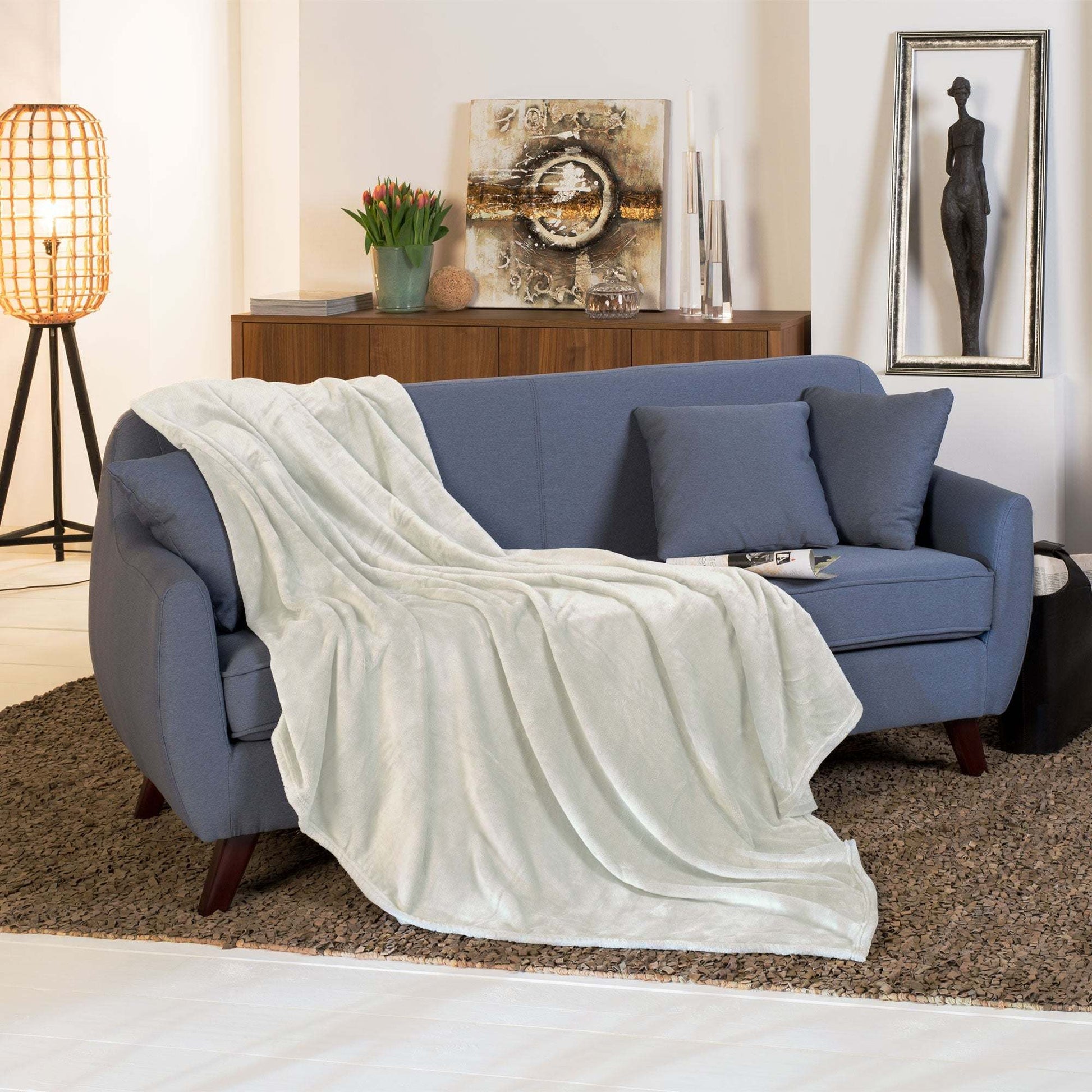 Beautissu XXL Tagesdecke Kuscheldecke Aurelia 220x240cm on sofa, elegant coral-fleece throw for home decor.