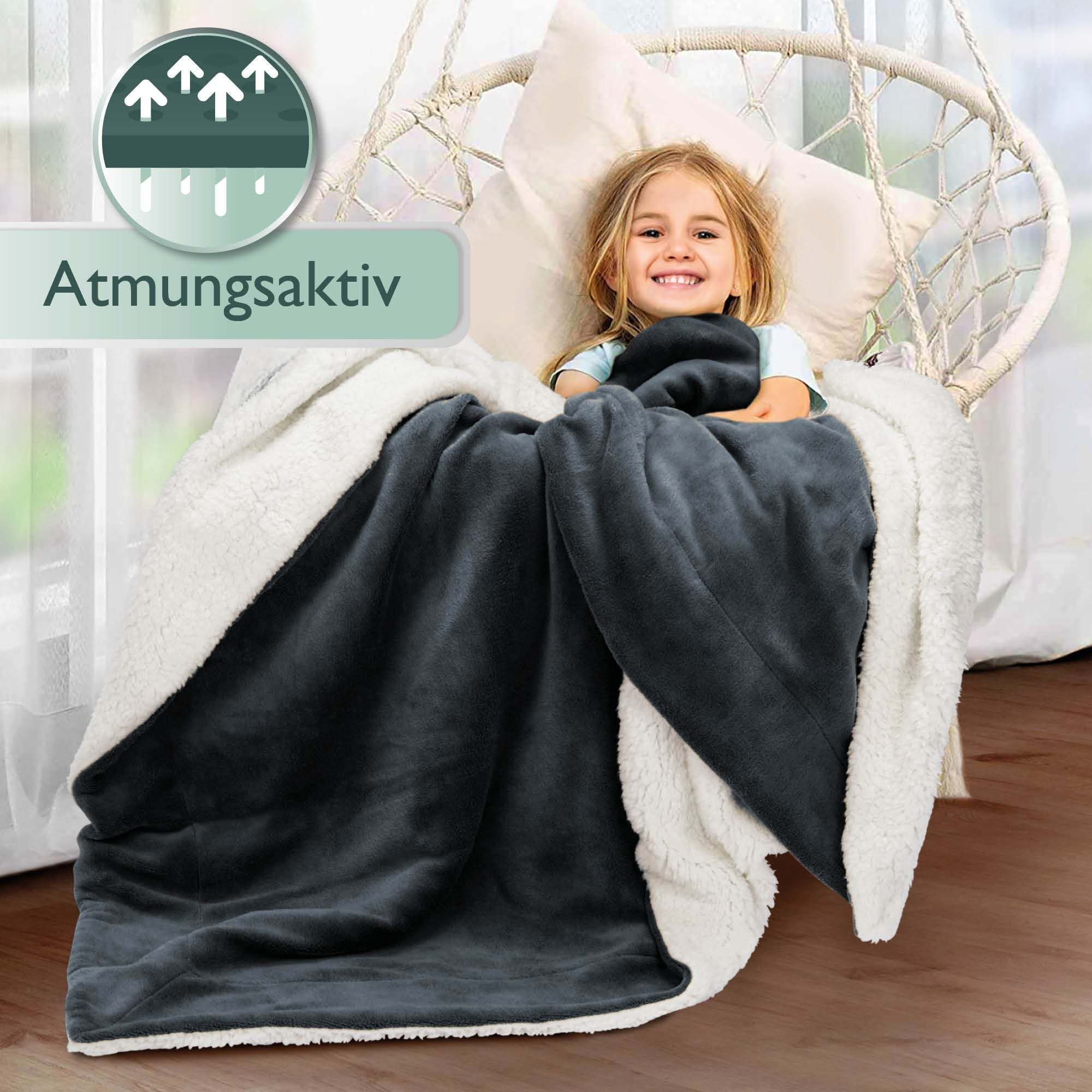 Child wrapped in Beautissu Sherpa Kuscheldecke Alina, cozy and warm microfiber polyester blanket, with breathable lamb-fleece look.