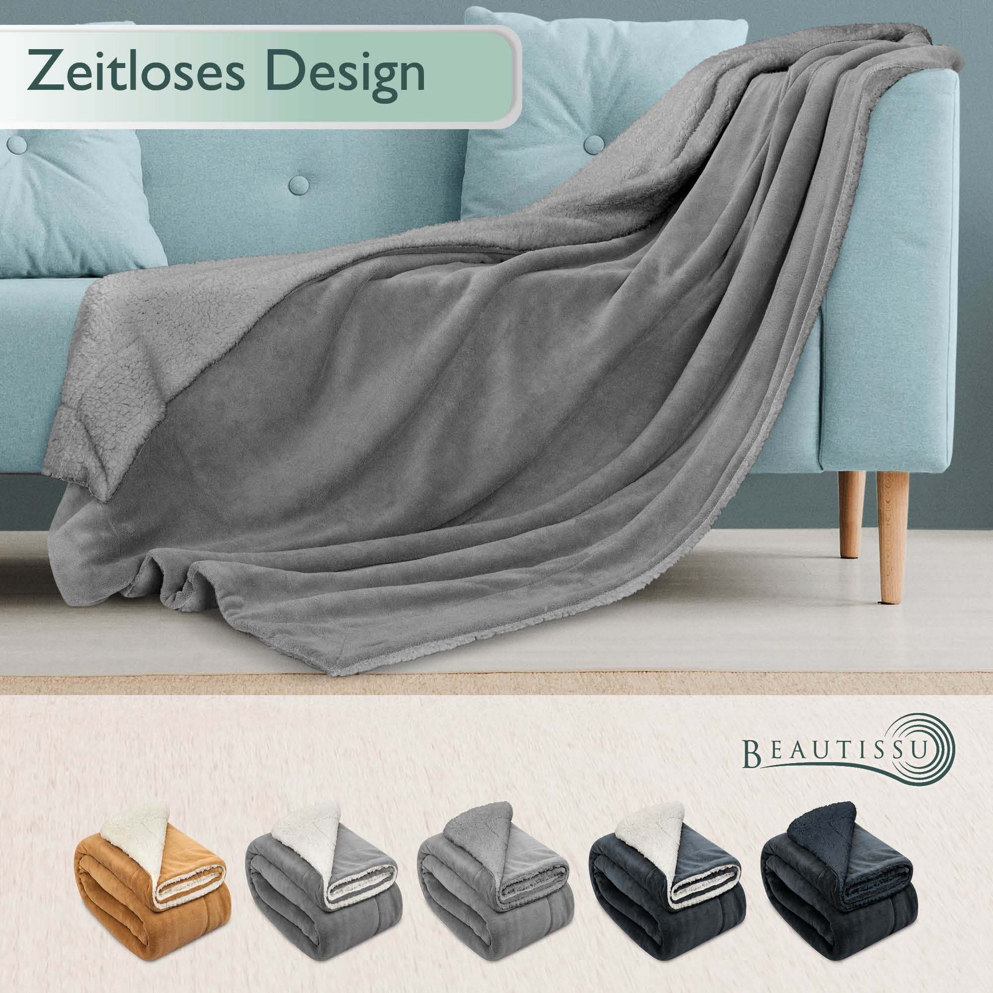 Beautissu Sherpa Kuscheldecke Alina in verschiedenen Farben drapiert über Sofa, erhältlich in Größen 150x200cm und 220x240cm.