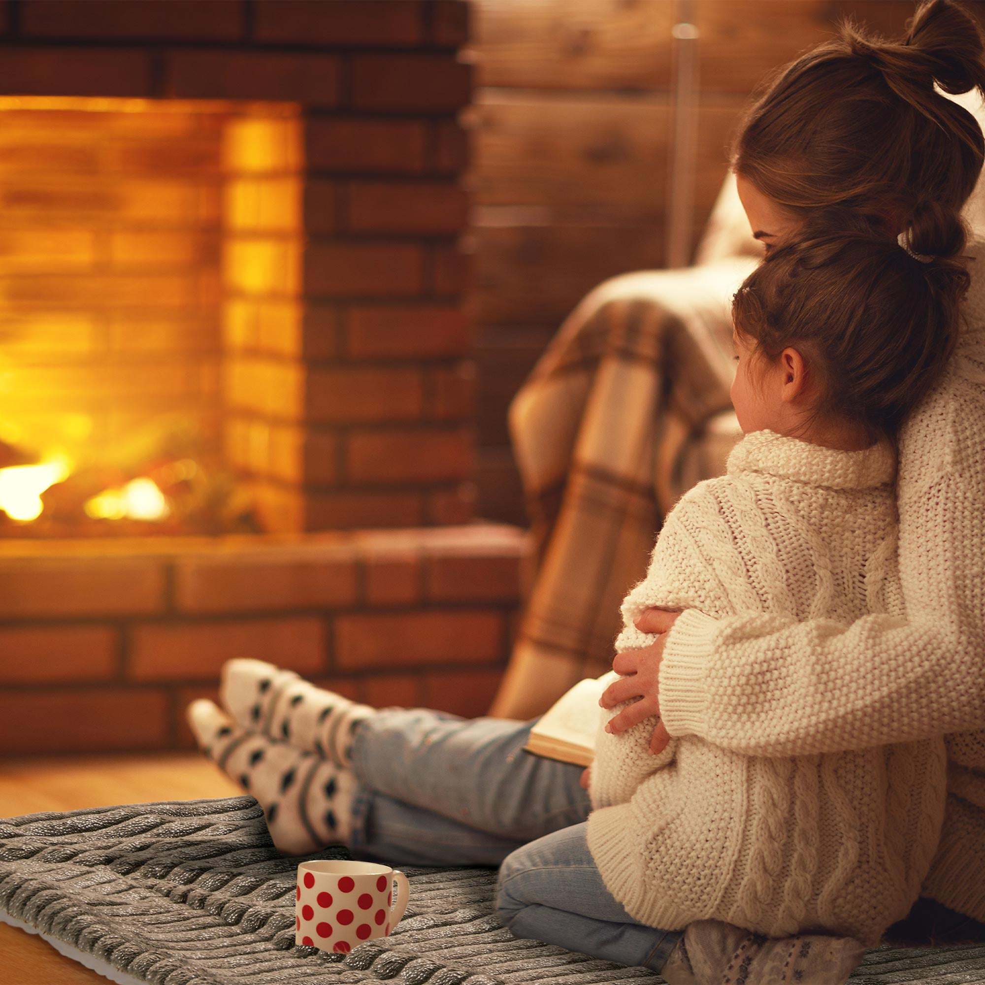 Cozy family by the fireplace wrapped in a plush Beautissu Sherpa Kuscheldecke Elisa blanket.