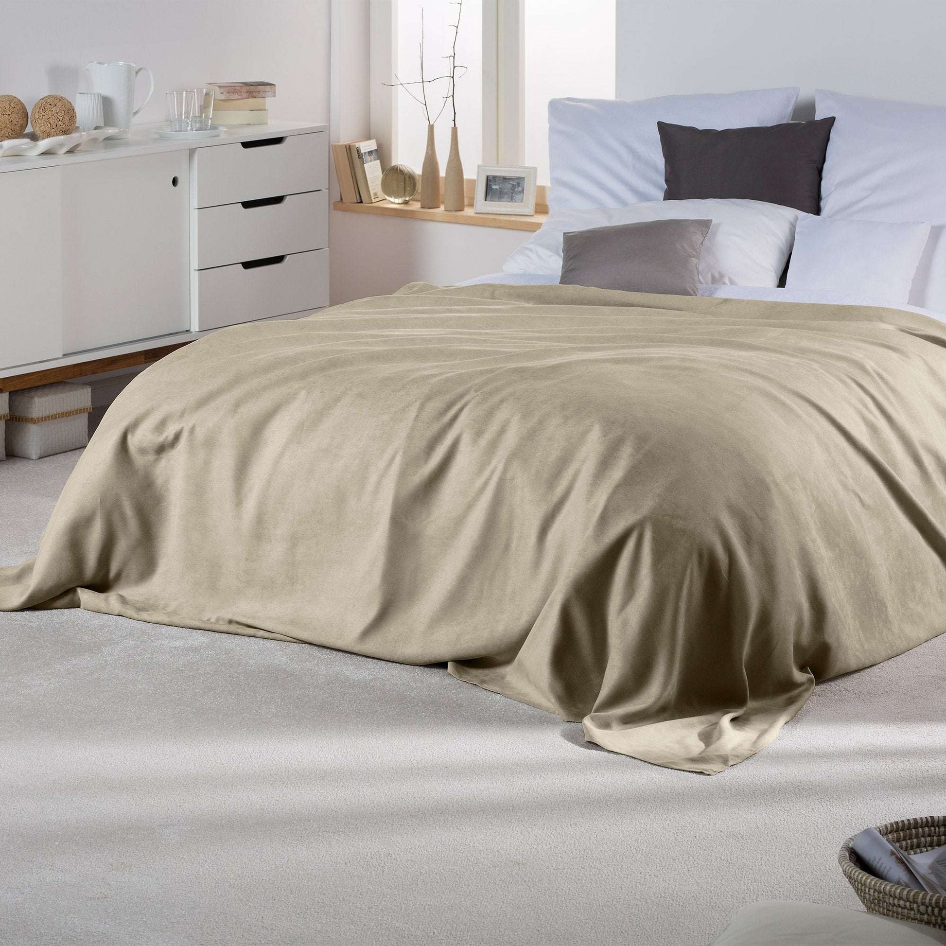 Beautissu Sofaüberwurf Romantica in Wildlederoptik, 210x280cm, beige, auf Bett drapiert.