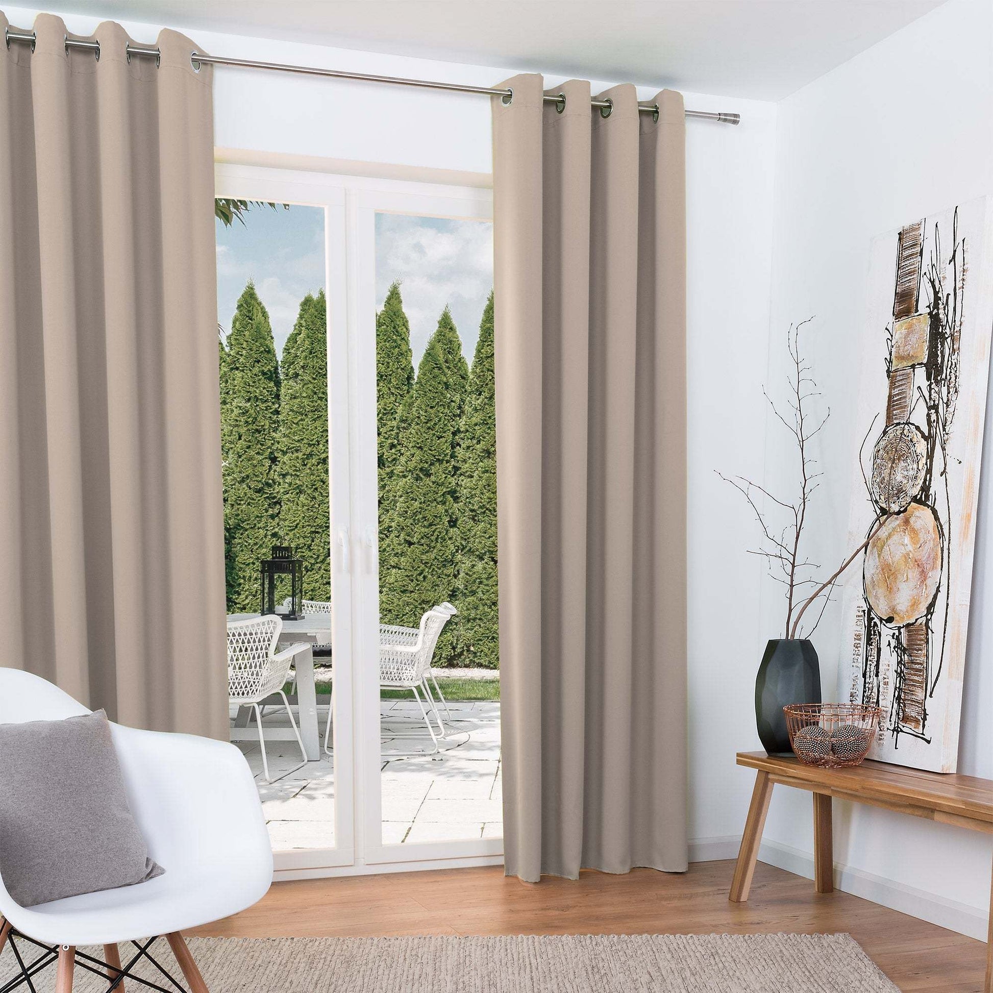 Beautissu Ösenschal Amelie blackout curtains in neutral room setting with garden view.