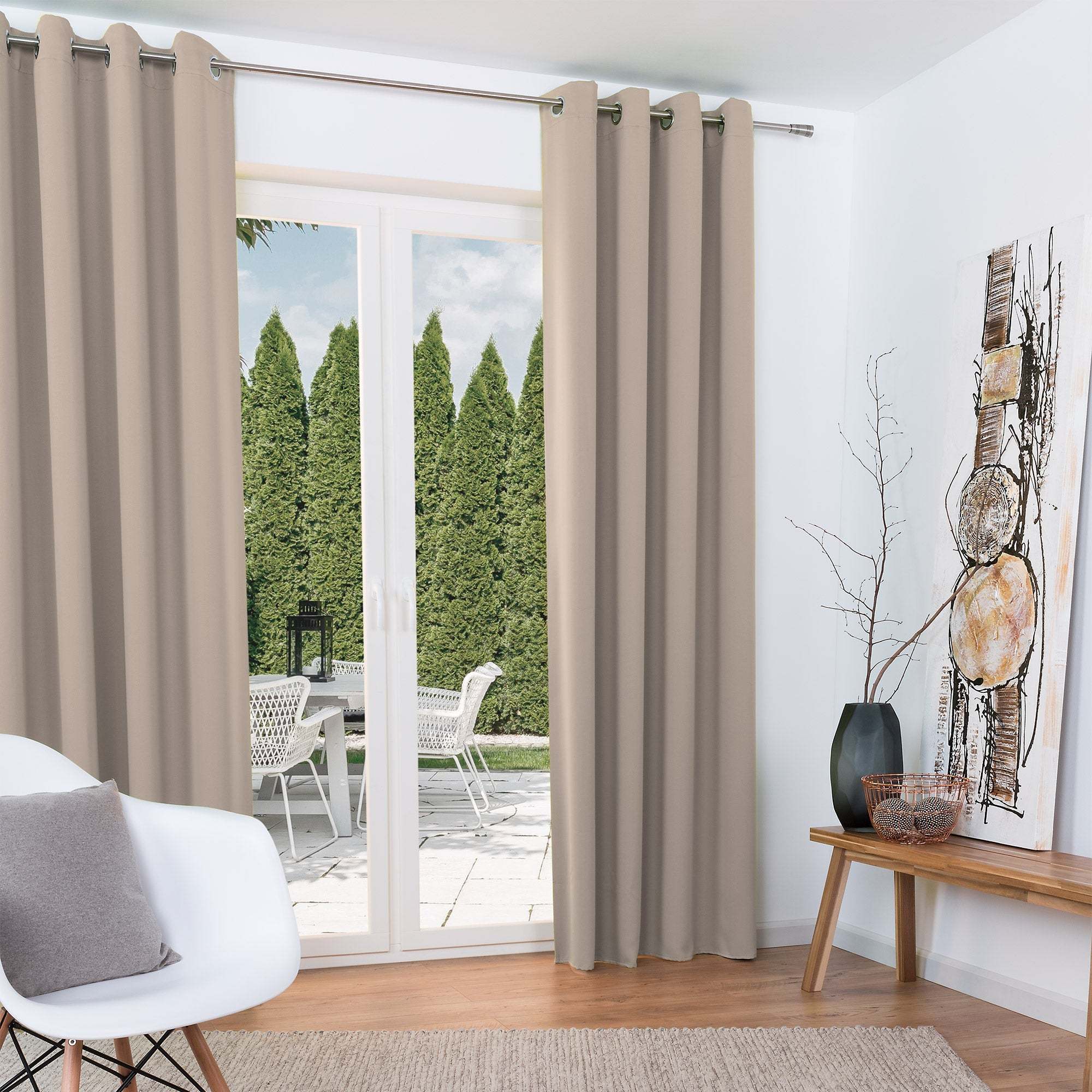 Beautissu Ösenschal Amelie blackout curtains in neutral room setting with garden view.