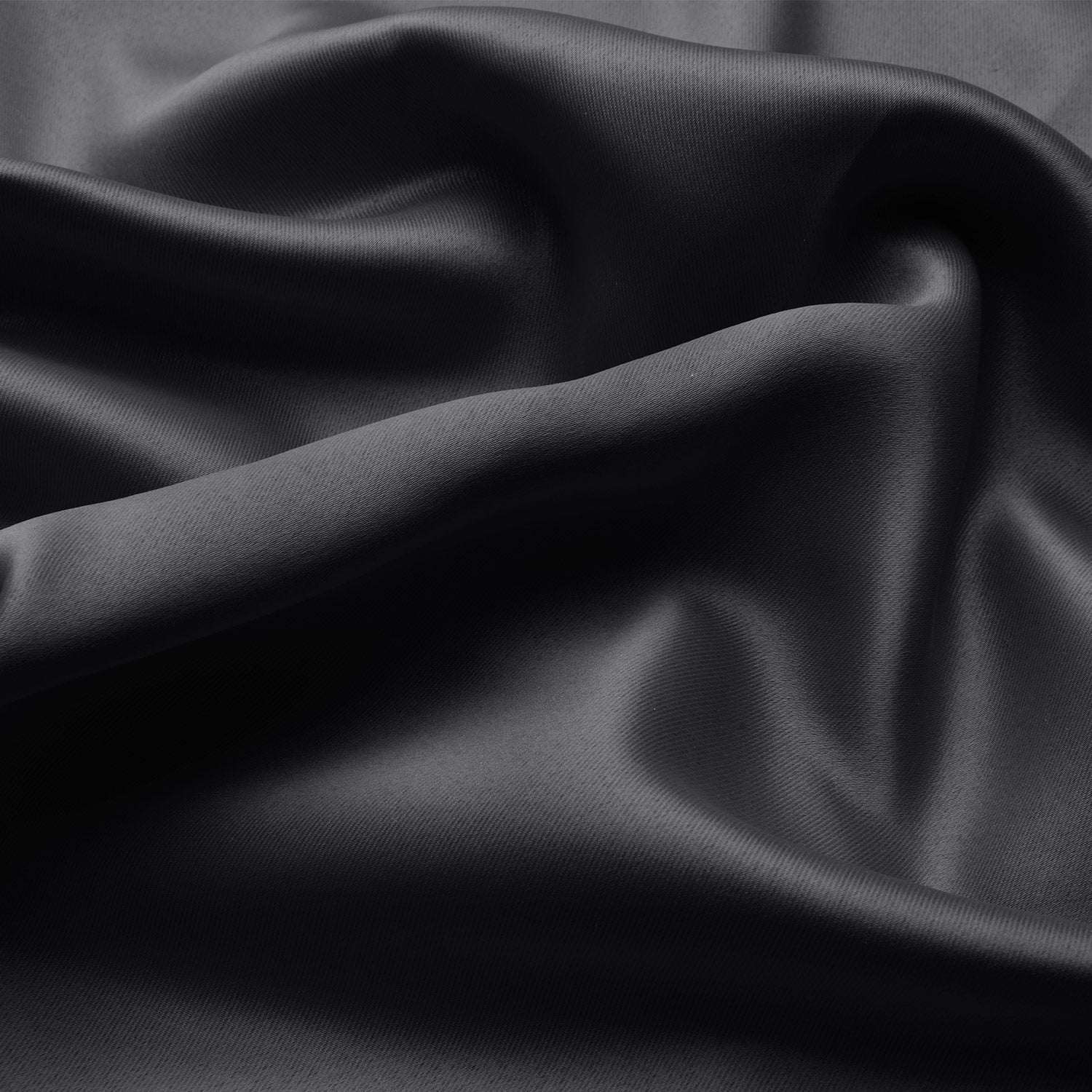 Beautissu Ösenschal Amelie blackout curtain fabric in black with soft folds and elegant sheen.