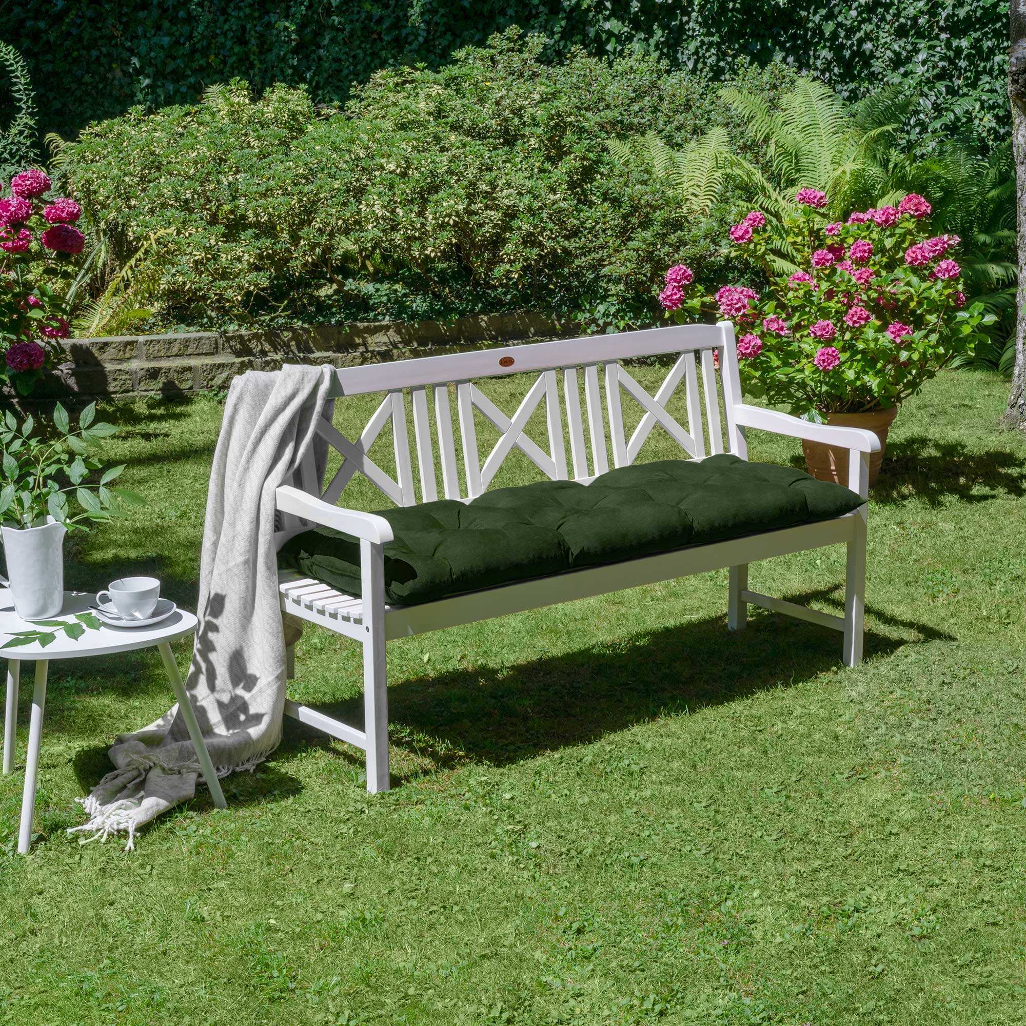 Beautissu Bankauflagen Flair BK cushion on a white garden bench in a lush outdoor setting.