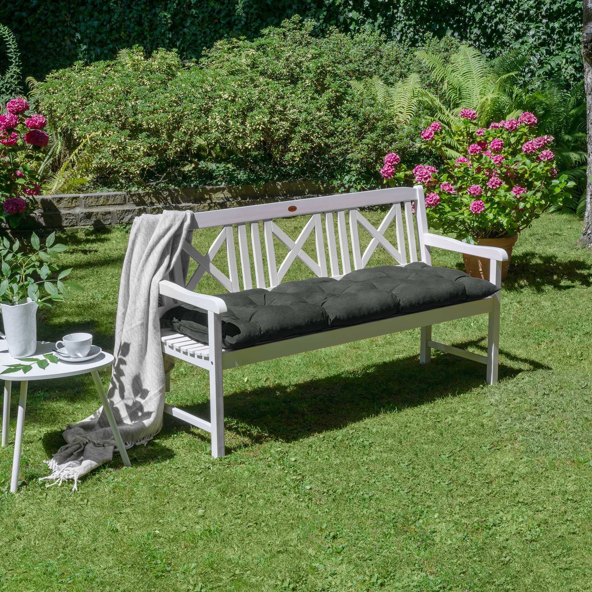 Beautissu Bankauflagen Flair BK cushion on a white garden bench in a lush garden setting.