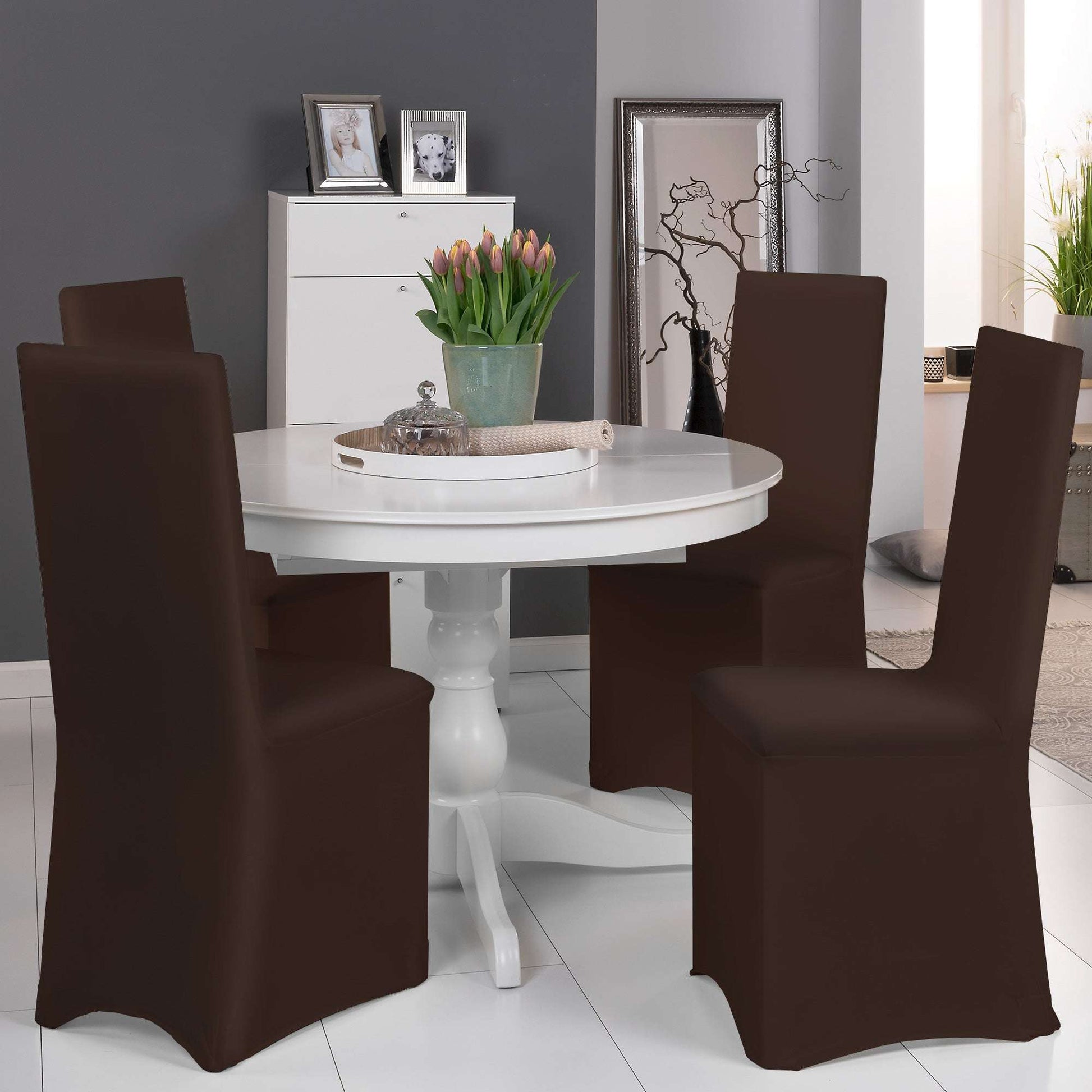 Beautissu Leona Stretch bankettstuhlhusse in diverse Farben auf Stühlen um runden Tisch in modern eingerichtetem Raum.