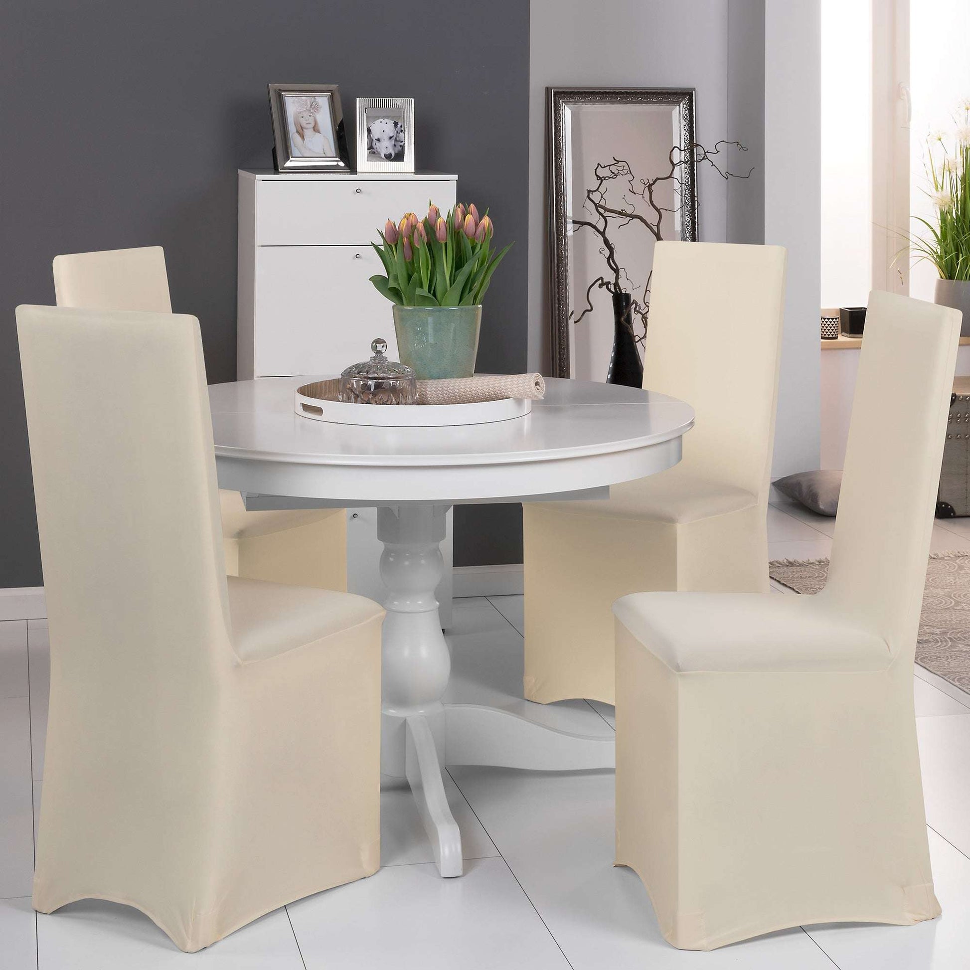Beautissu Leona Stretch banquet chair cover in various colors on dining chairs around a white table.