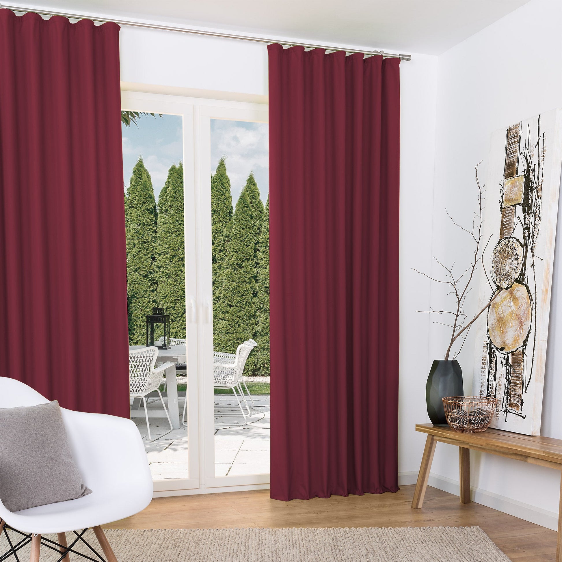 Red thermally insulated curtains by Beautissu with a gathered tape design, hanging elegantly in a modern living room.