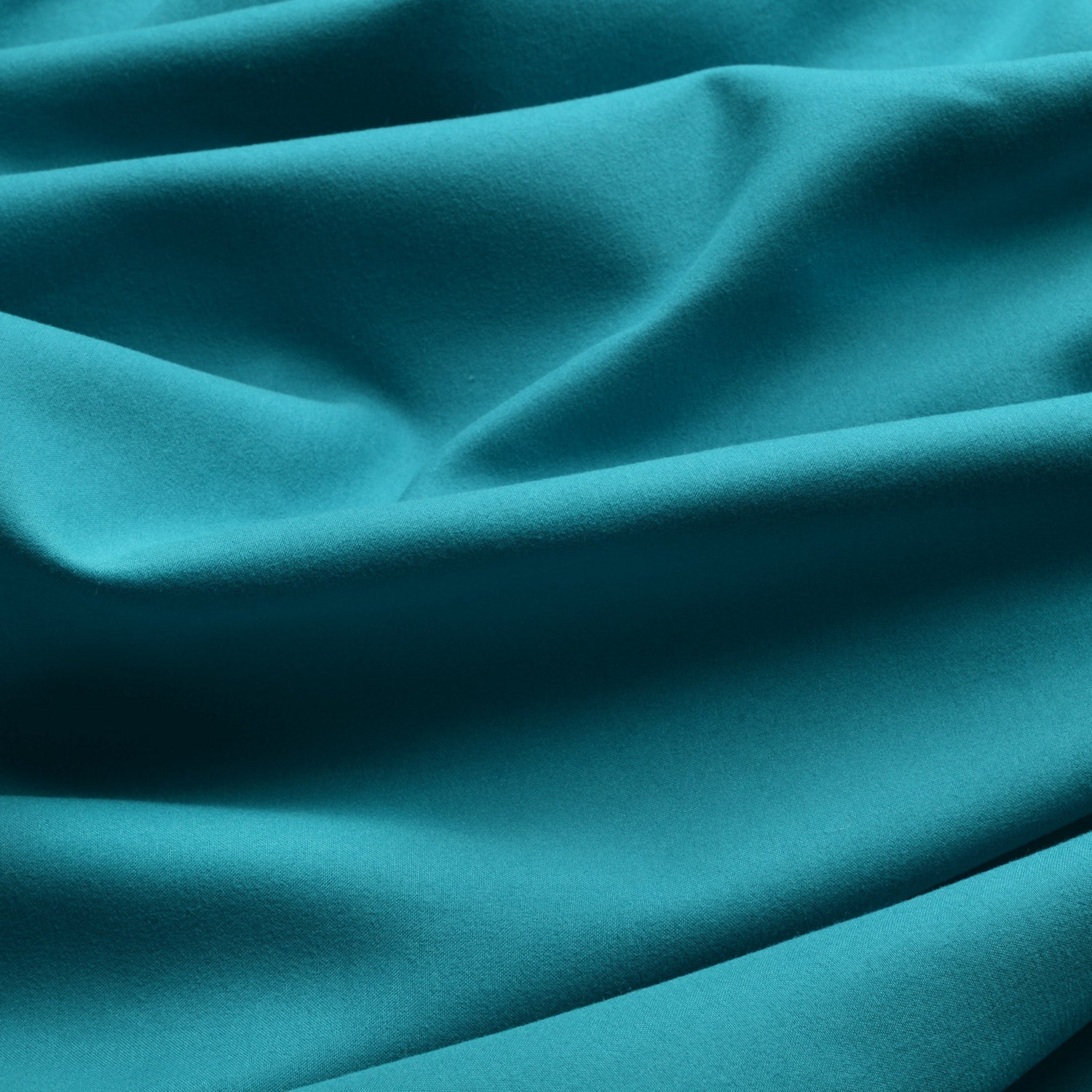 Thermal curtains in vibrant teal, featuring a soft, flowing texture and elegant folds, part of the Beautissu Kräuselband Amelie collection.