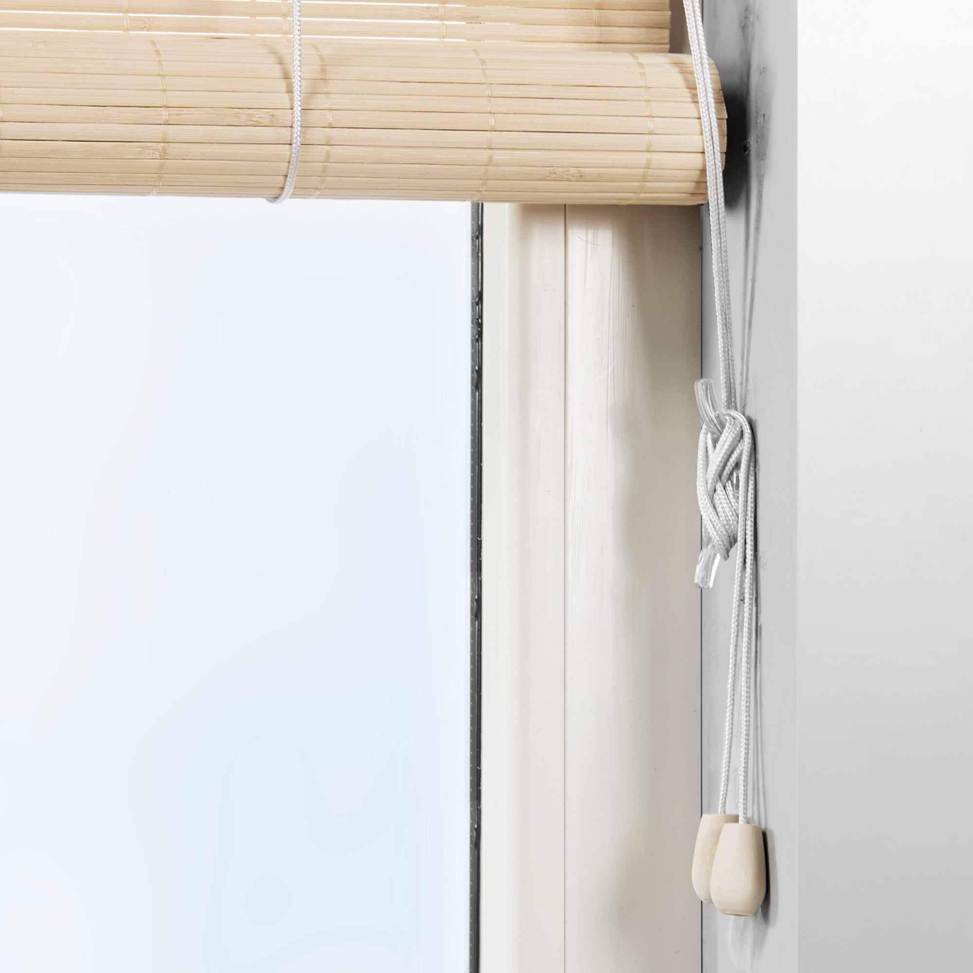 Sol Royal SolDecor B86 bamboo roller blind in natural wood color, showing its adjustable pull cord and easy mounting on a window frame.